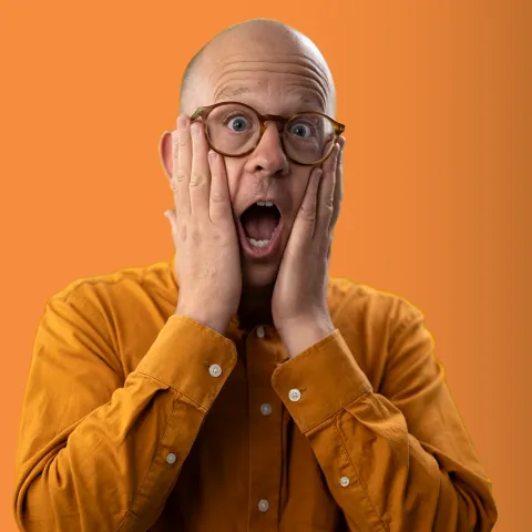 Kevan with hands on his cheeks, mouth open in mock shock
